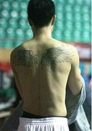 顶天立地的男子背部翅膀纹身图案图片